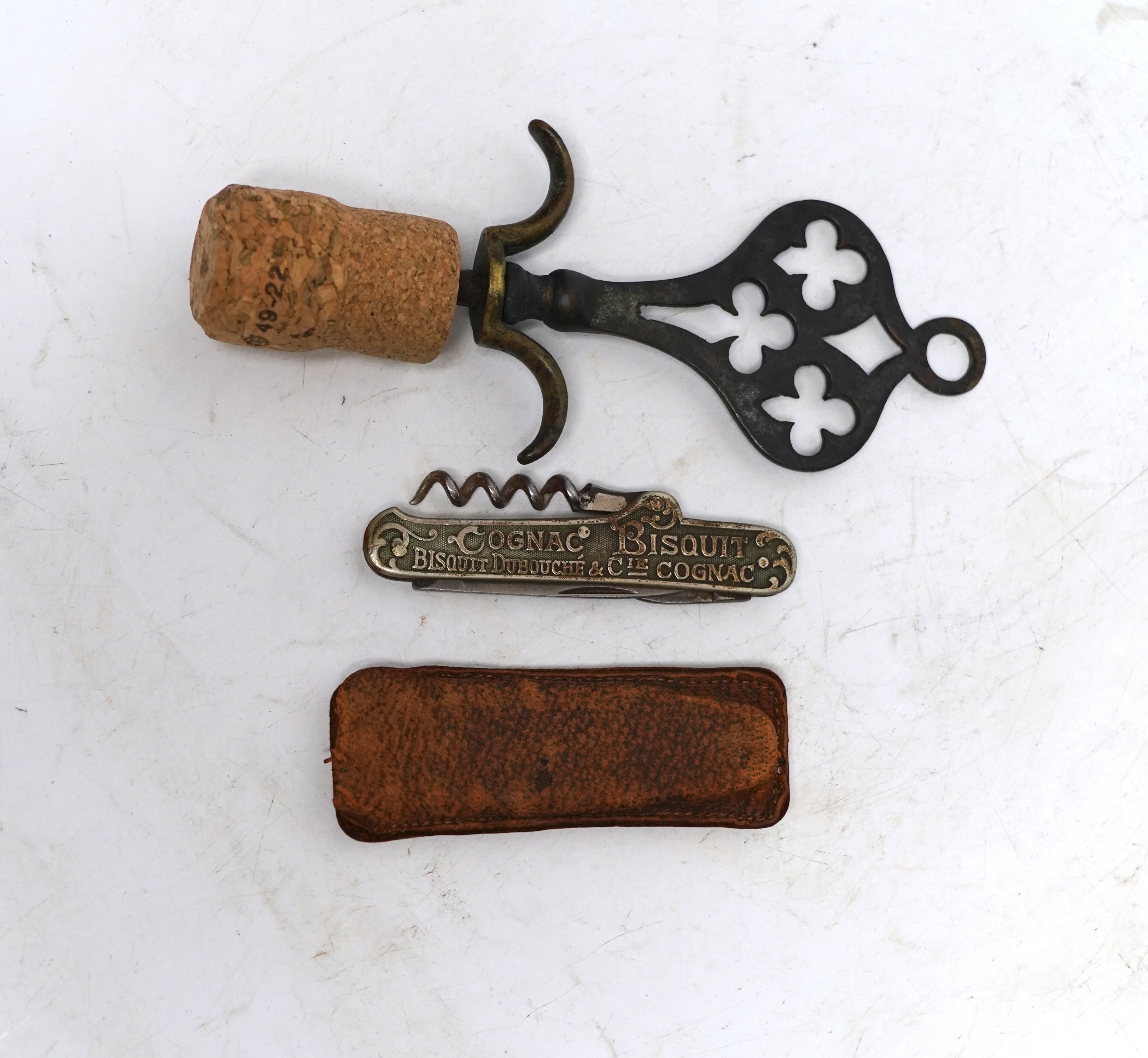 Two corkscrews; one advertising Jean E Sottiris-Le Caire, on reverse, Cognac Bisquit, Bisquit Du Bouche &Cie Cognac together with an ornate brass corkscrew largest 14cm